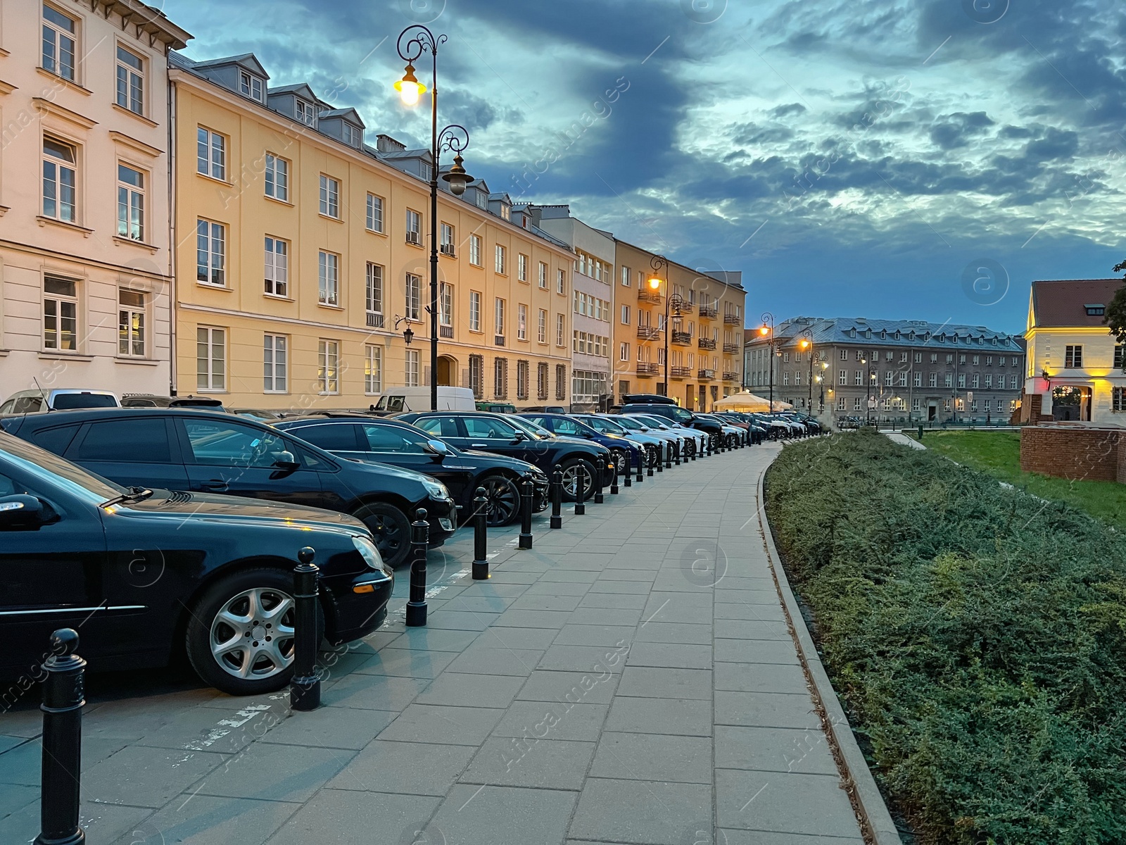 Photo of Cityscape with cars parked along street in evening