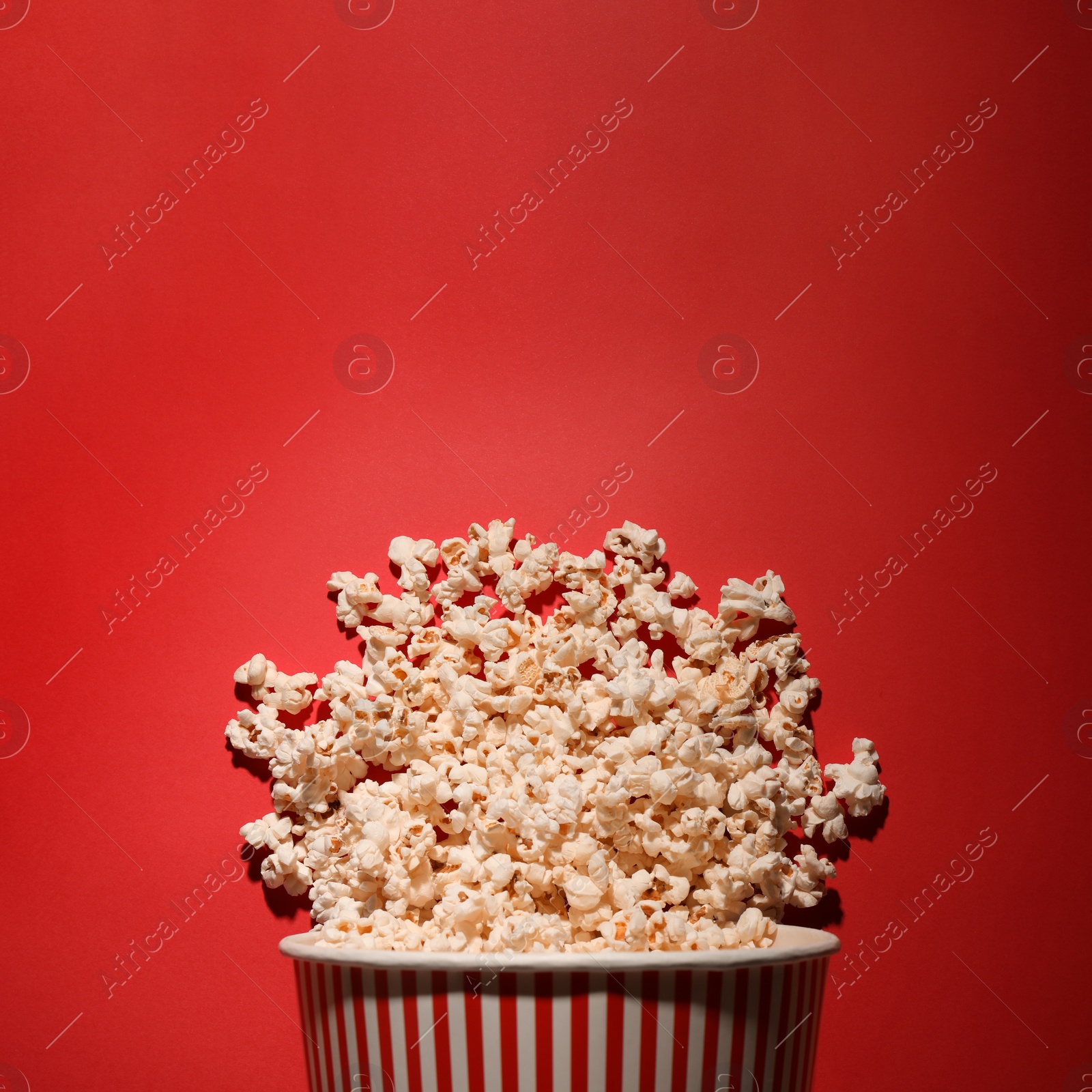 Photo of Delicious popcorn on red background, top view