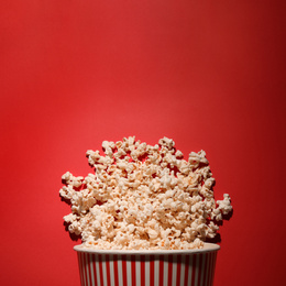 Photo of Delicious popcorn on red background, top view