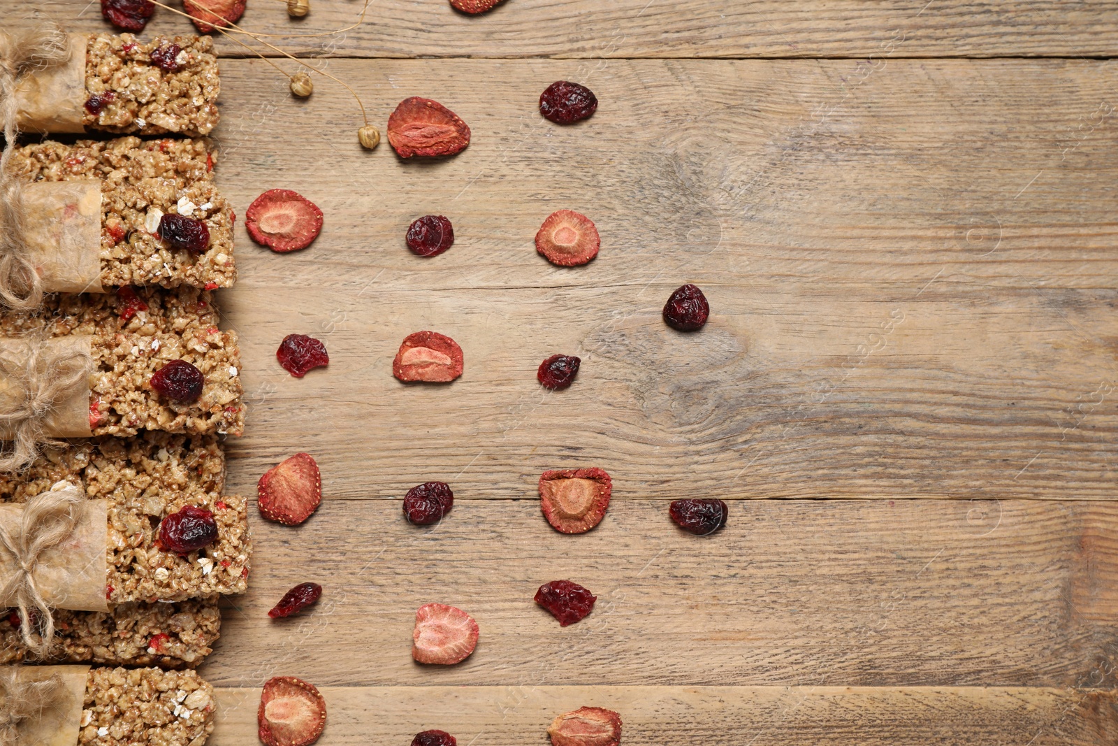 Photo of Tasty granola bars on wooden table, flat lay. Space for text