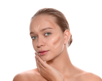 Young woman with different shades of skin foundation on her face against white background