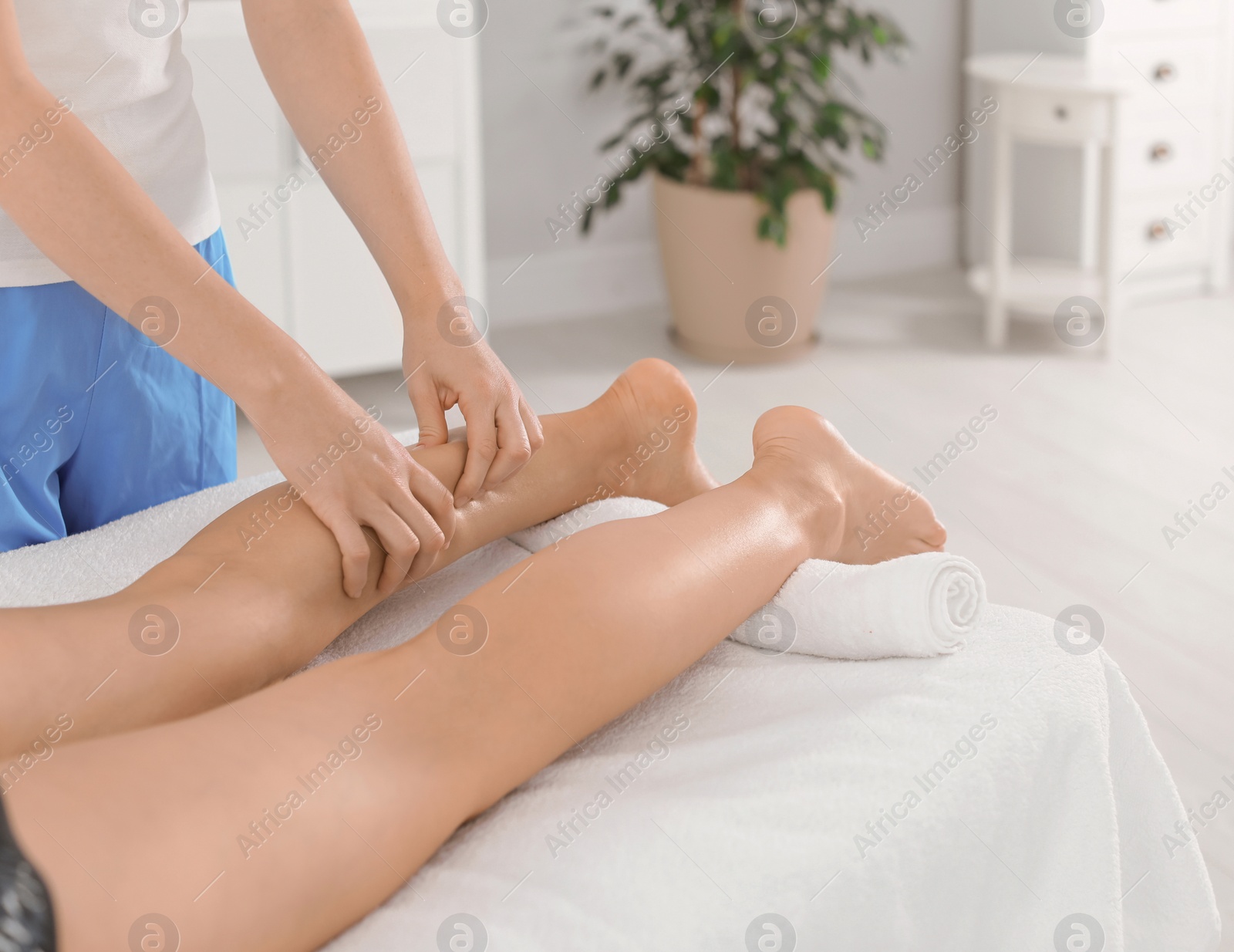 Photo of Woman receiving leg massage in wellness center