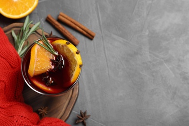 Photo of Tasty mulled wine on grey table, flat lay. Space for text
