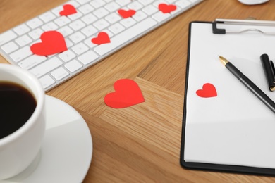 Photo of Red hearts, keyboard and coffee on wooden table. Valentine's day celebration