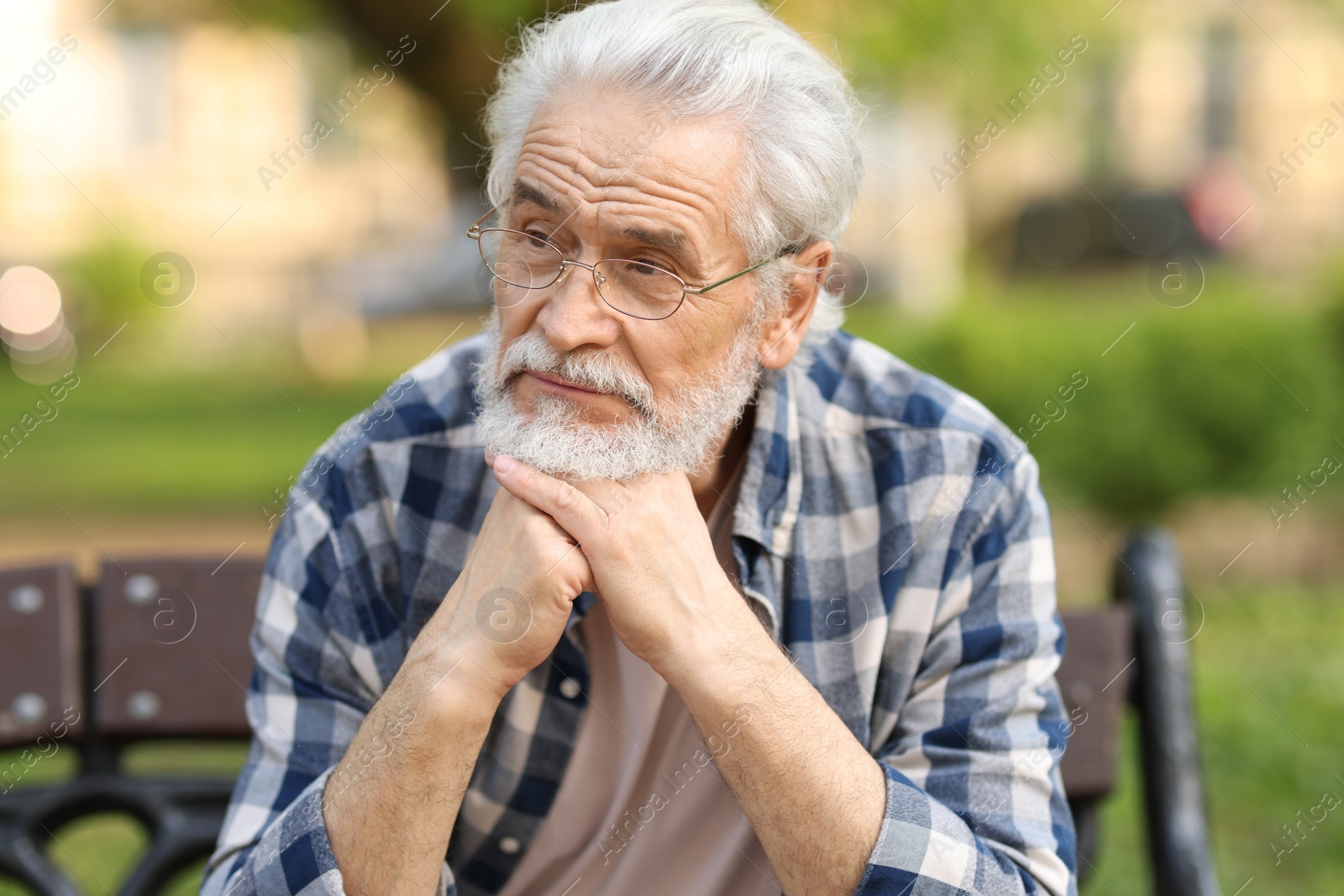 Photo of Portrait of happy grandpa with glasses on bench in park