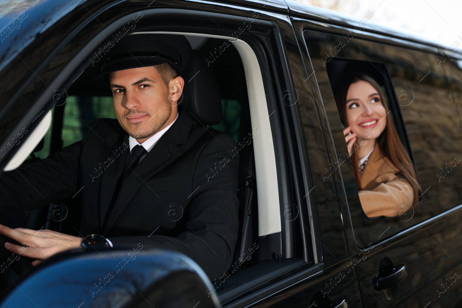 Photo of Professional driver and businesswoman in luxury car. Chauffeur service