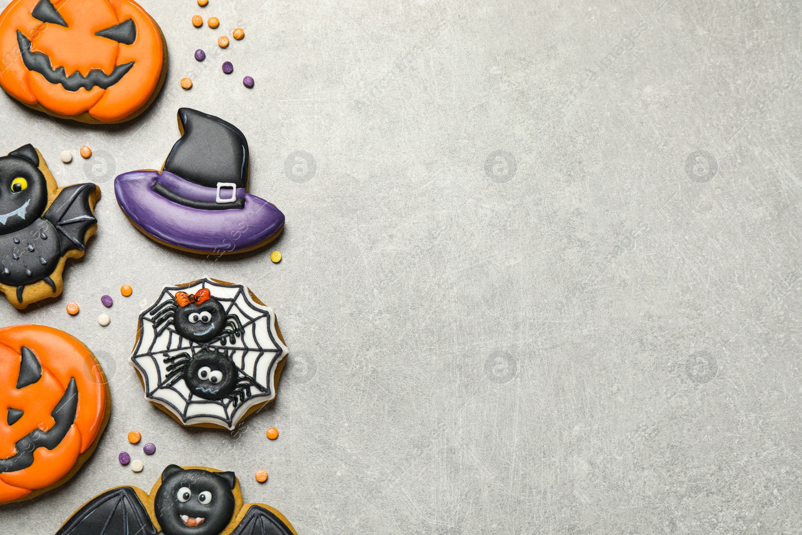 Photo of Tasty Halloween cookies on light grey table, flat lay. Space for text