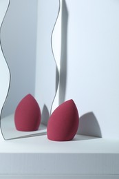 Photo of Stylish presentation of makeup sponge on light grey background