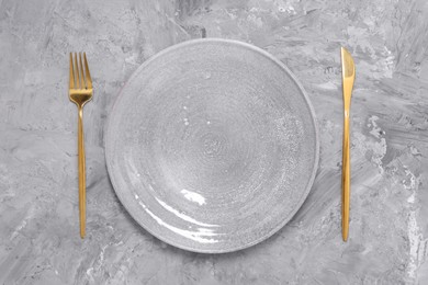 Photo of Elegant setting with shiny cutlery on grey table, top view