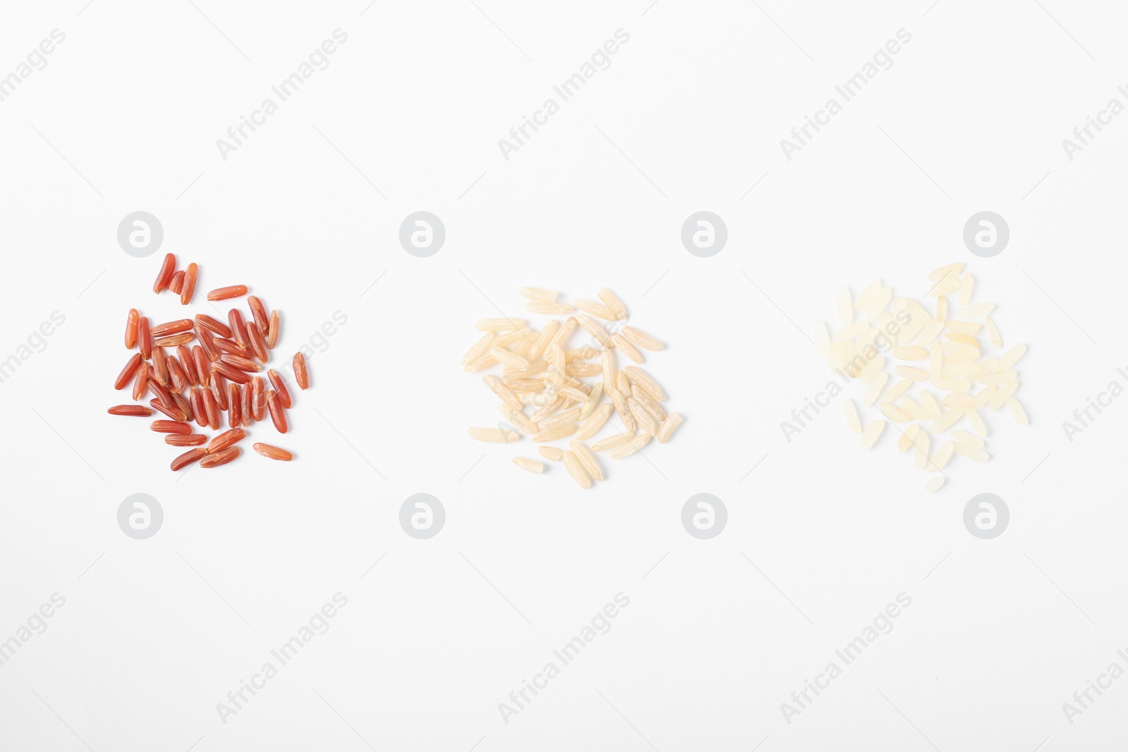 Photo of Different types of uncooked rice on white background, top view