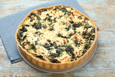 Delicious homemade spinach quiche on rustic wooden table, closeup