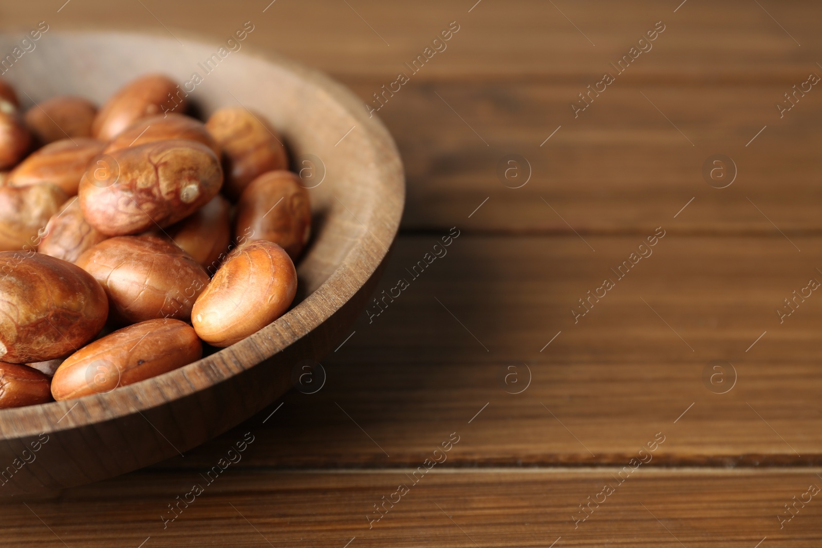 Photo of Plate of jackfruit seeds on wooden table, closeup. Space for text