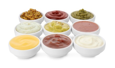 Photo of Many different sauces in bowls on white background