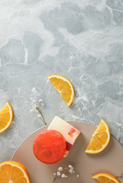 Flat lay composition with soap and orange slices on light grey marble background. Space for text