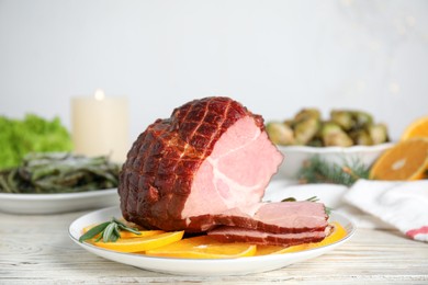 Photo of Delicious ham served with orange and rosemary on white wooden table