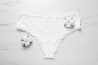 Photo of Elegant women's underwear and cotton flowers on white marble background, flat lay