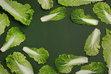 Frame with fresh ripe leaves of Chinese cabbage on green background, flat lay. Space for text