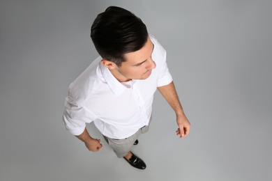 Businessman in formal clothes on grey background, above view