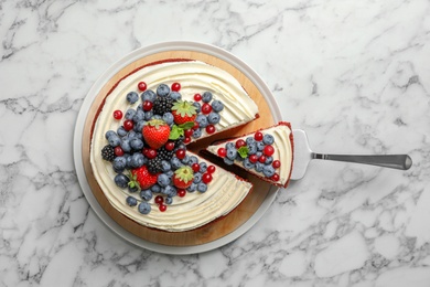 Photo of Delicious homemade red velvet cake with fresh berries on marble table, top view