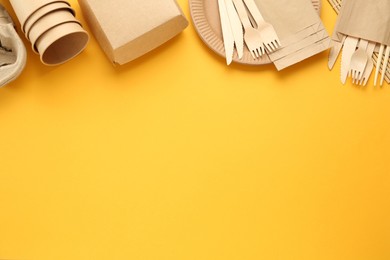 Flat lay of paper and wooden tableware on yellow background, space for text. Eco friendly lifestyle