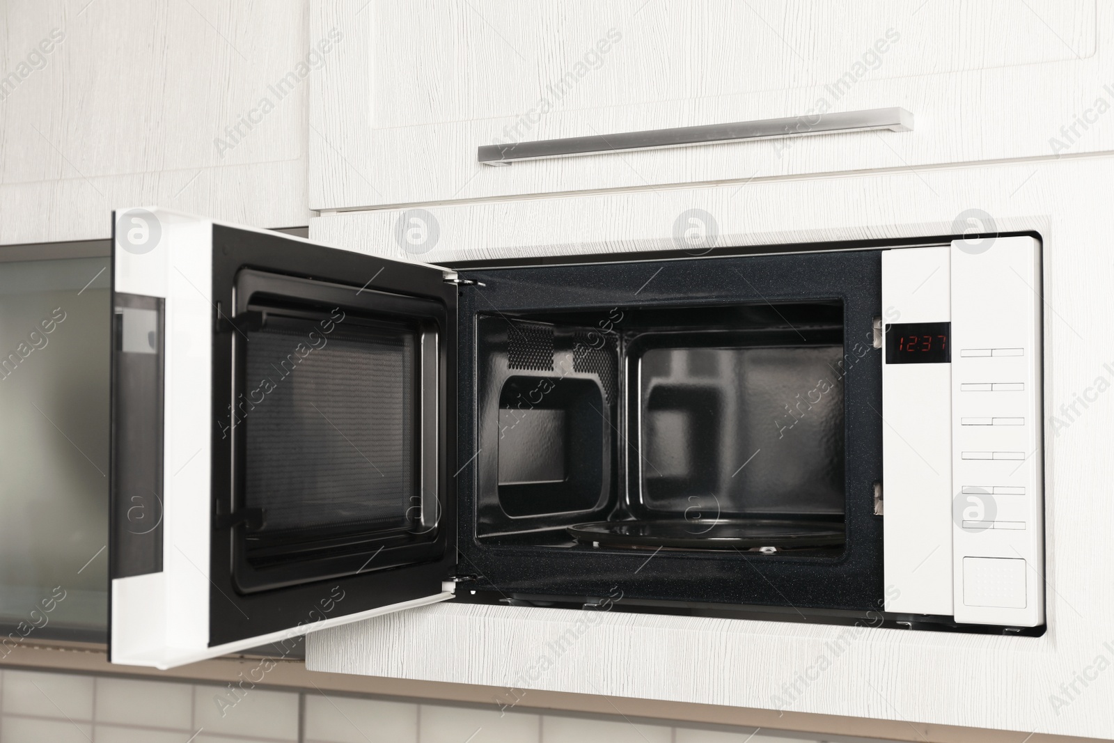 Photo of Open modern microwave oven built in kitchen furniture