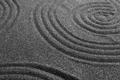 Photo of Pattern on decorative black sand, closeup. Zen and harmony