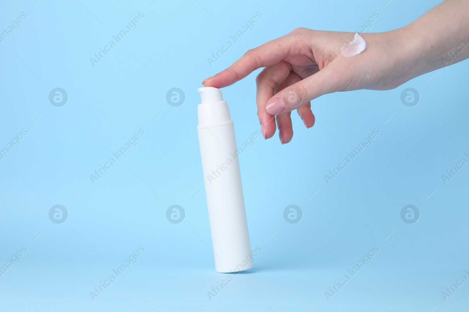 Photo of Woman with cream on light blue background, closeup