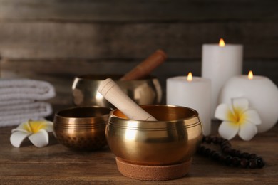 Photo of Composition with golden singing bowls on wooden table