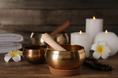 Composition with golden singing bowls on wooden table