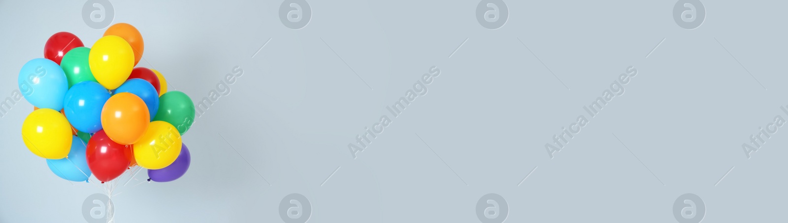 Image of Bunch of bright balloons on pale light blue background, space for text. Banner design 