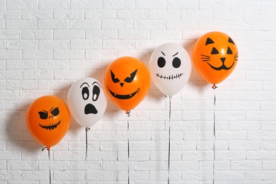 Photo of Color balloons for Halloween party against white brick wall