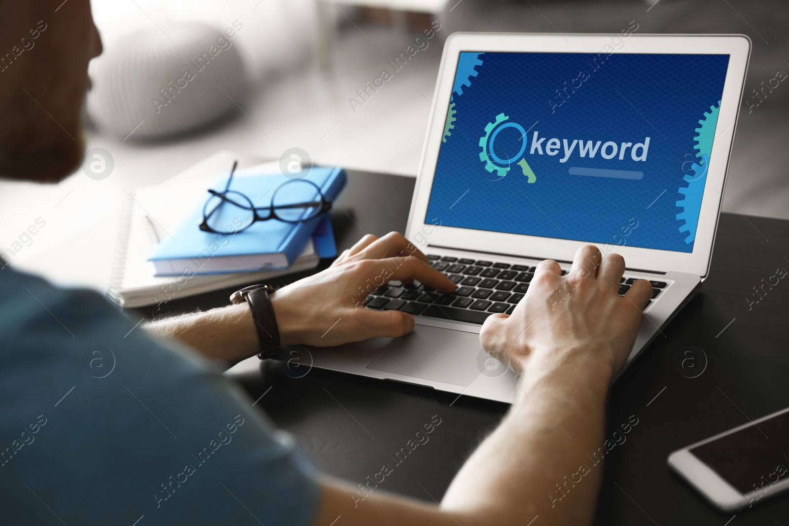 Image of Keywords research concept. Man working with laptop at table indoors, closeup