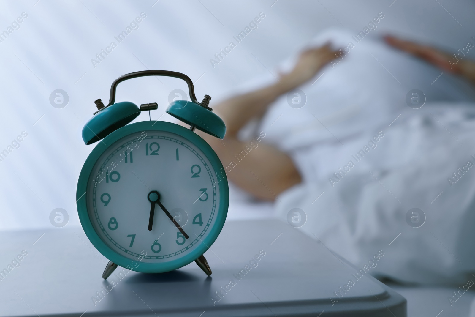 Photo of Sleepy man awaking at home in morning, focus on alarm clock. Space for text