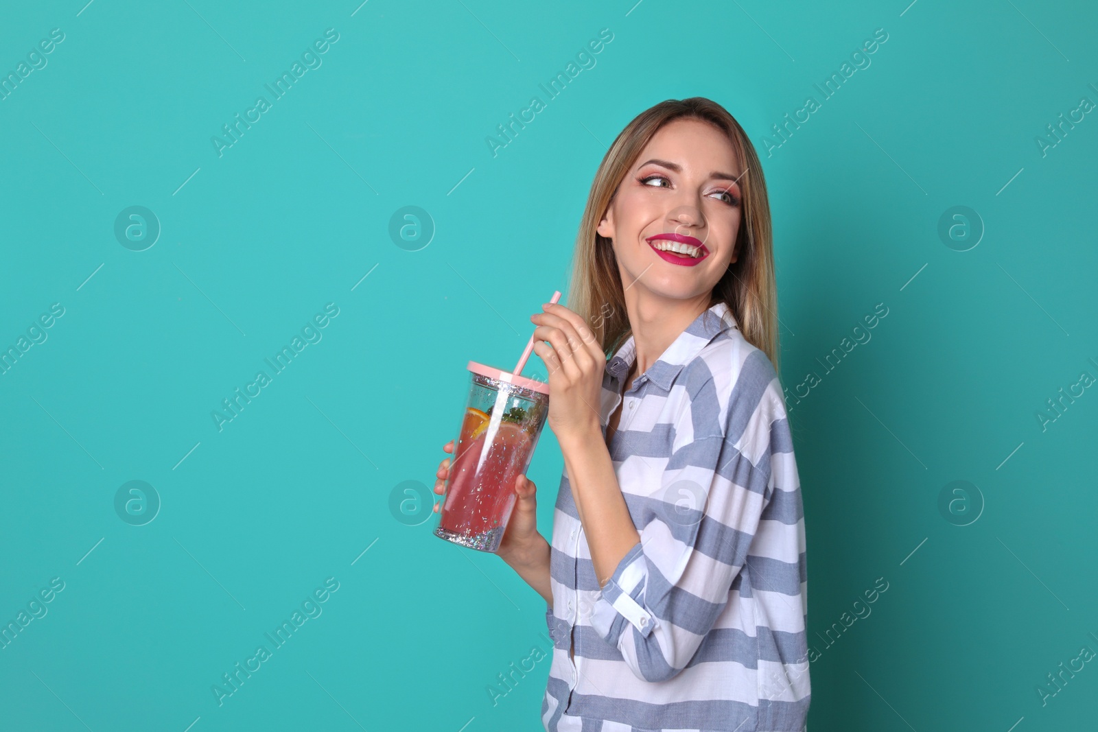 Photo of Young woman with tasty lemonade on color background. Natural detox drink