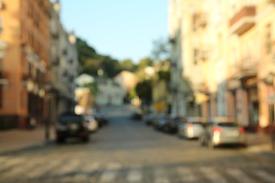 Blurred view of quiet city street with buildings and parked cars