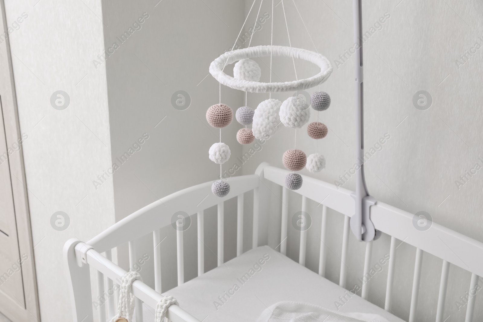 Photo of Modern baby mobile under crib in children's room