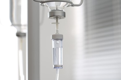 Photo of IV drip chamber against blurred light background