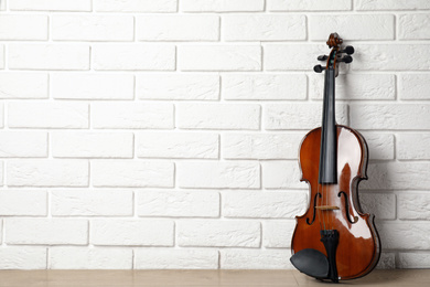 Photo of Classic violin near white brick wall. Space for text