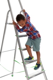 Little African-American boy climbing up ladder on white background. Danger at home