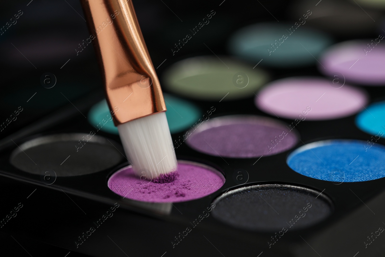 Photo of Colorful eyeshadow palette with brush, closeup view