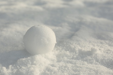 Photo of Perfect snowball on snow outdoors, closeup. Space for text