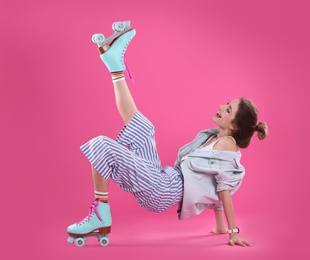 Young woman with retro roller skates on color background