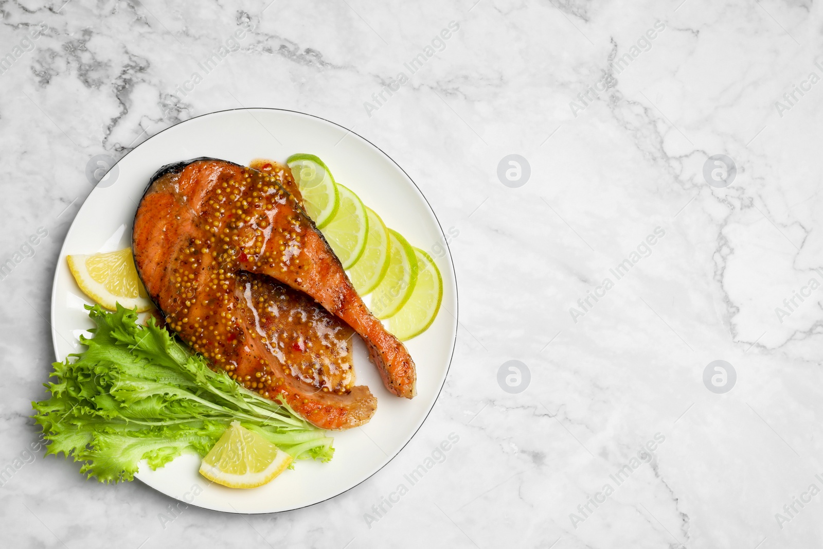 Photo of Tasty salmon steak with sauce, citrus slices and lettuce on white marble table, top view. Space for text