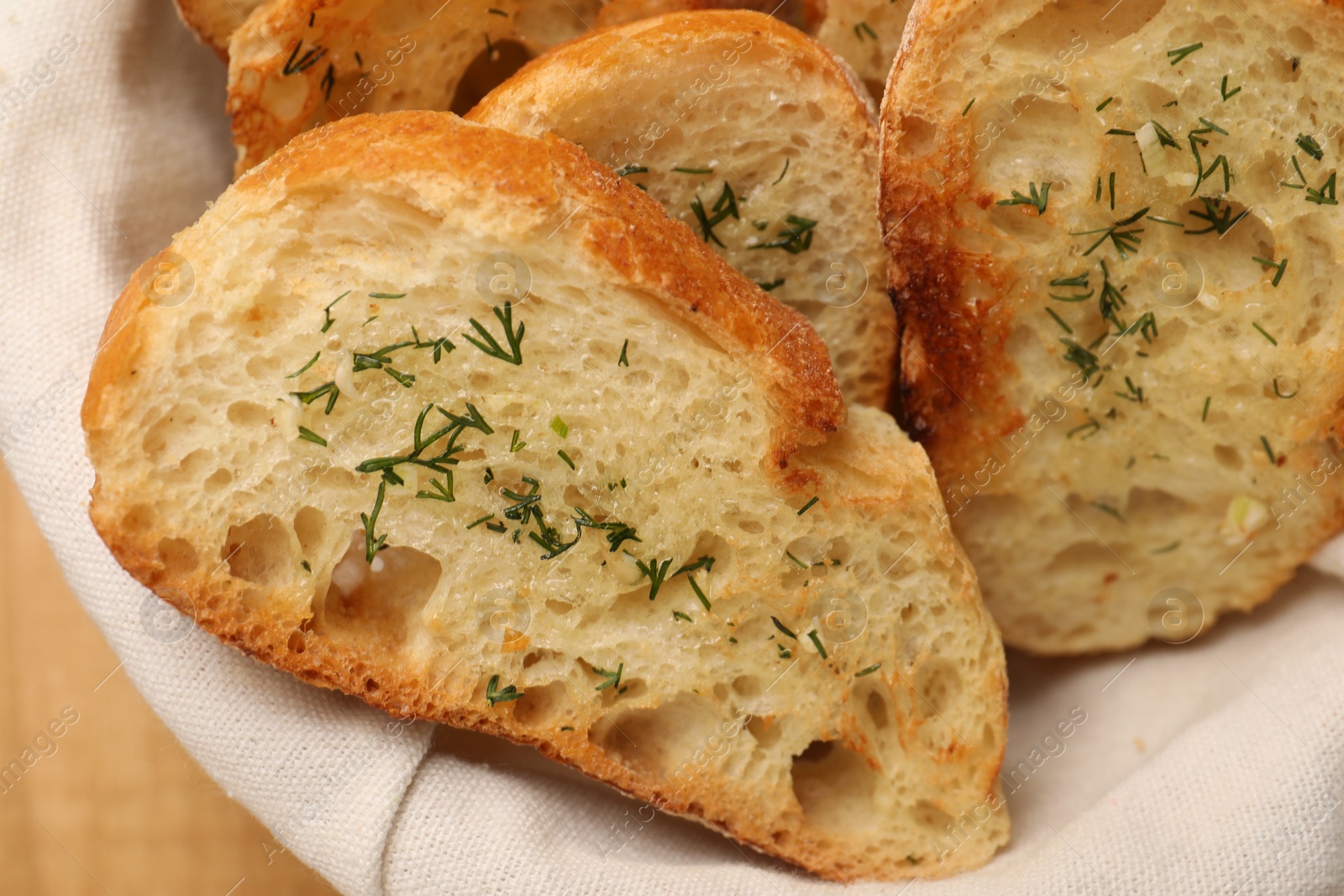 Photo of Tasty baguette with garlic and dill on table, closeup