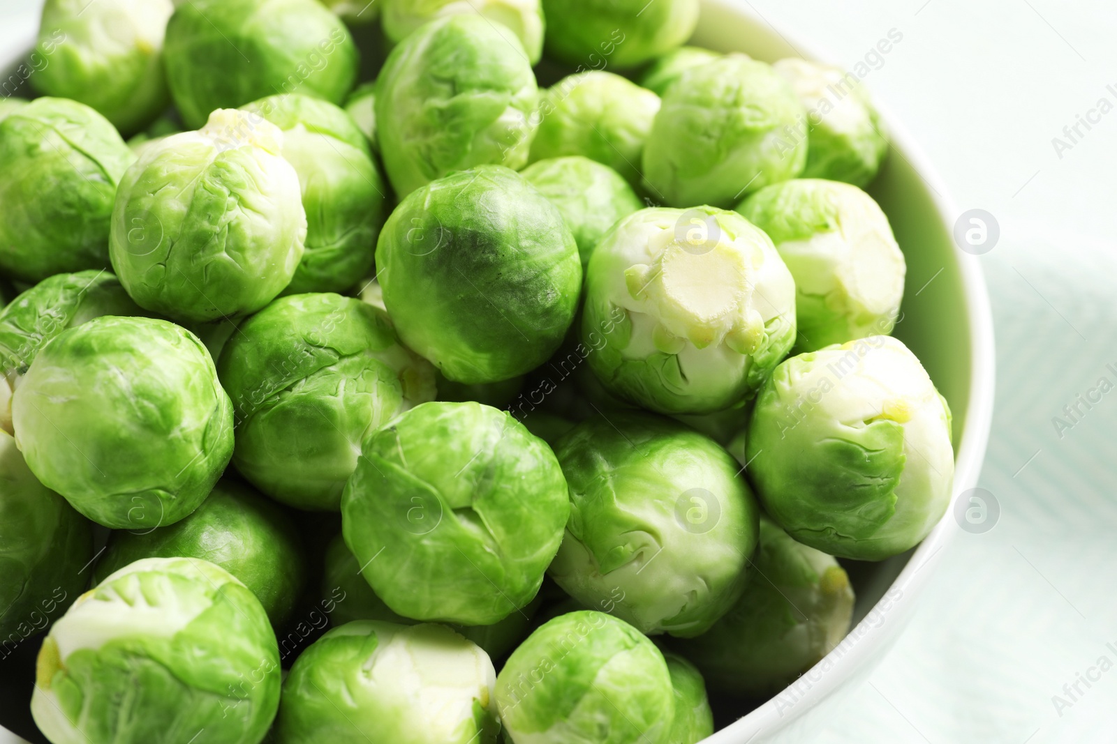 Photo of Bowl of fresh Brussels sprouts on table, closeup