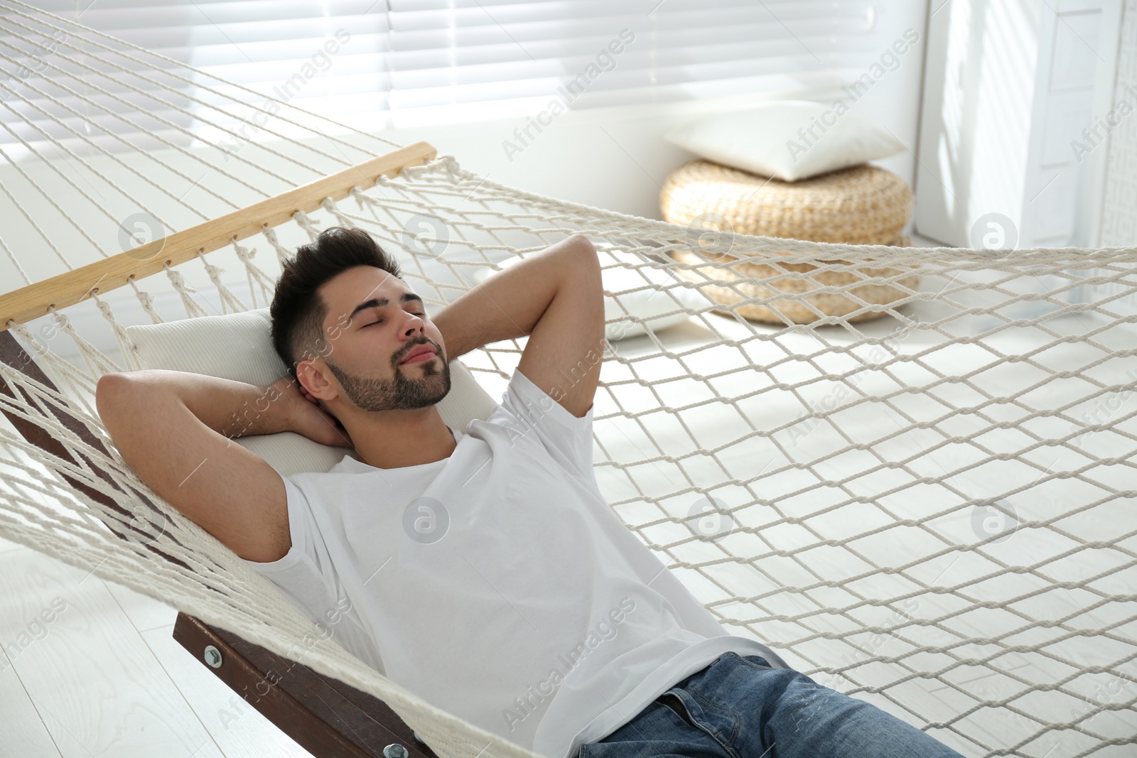 Photo of Young man relaxing in hammock at home