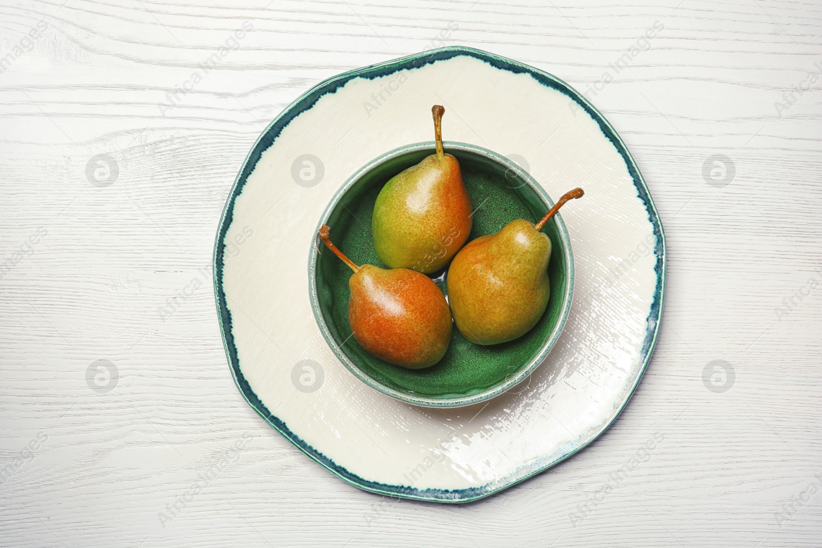 Photo of Dishware with pears on wooden background, top view