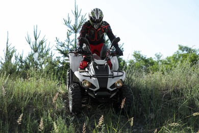 Photo of Man driving modern quad bike outdoors. Extreme sport