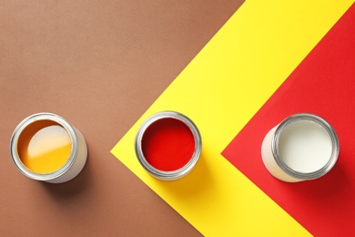 Flat lay composition with paint cans and space for text on color background