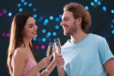 Happy couple with champagne in glasses on blurred background